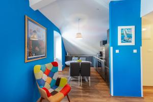 ein Wohnzimmer mit blauen Wänden und Stühlen sowie einem Tisch in der Unterkunft Captain's Place in Dubrovnik