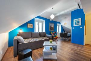 ein Wohnzimmer mit einem Sofa und einer blauen Wand in der Unterkunft Captain's Place in Dubrovnik