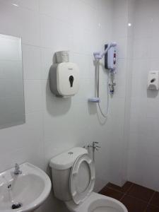 a white bathroom with a toilet and a sink at New Century Hotel Melaka in Melaka