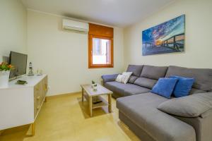 a living room with a couch and a tv at Vivalidays Urban Tossa House in Tossa de Mar