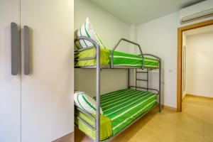 a bunk bed in a room with green bunk beds at Vivalidays Urban Tossa House in Tossa de Mar