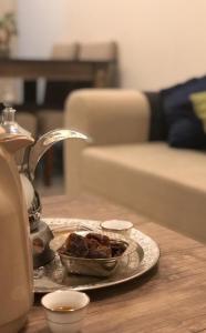 um prato de comida numa mesa numa sala de estar em Aris Furnished Apartments em Buraydah