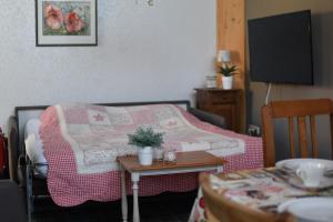 a room with a bed with a pink blanket and a table at Hof Kricheleberg in Bocholtz
