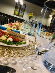 einen Tisch mit Teller mit Speisen und Gläsern Wein in der Unterkunft Penzion a Reštaurácia Hanišberg in Krupina