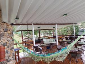 a hammock on a deck with tables and chairs at Sítio Corta Vento in Teresópolis