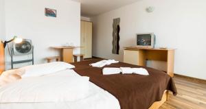 a bedroom with a bed with two towels on it at Hostel Sea Star in Vama Veche