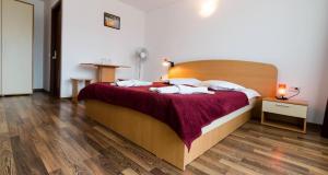 a bedroom with a large bed with a wooden headboard at Hostel Sea Star in Vama Veche +13 photos