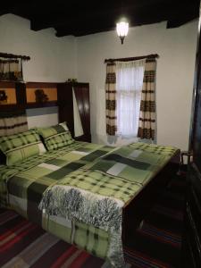ein Schlafzimmer mit einem großen Bett in einem Zimmer in der Unterkunft Къща за гости Ножери in Trjawna