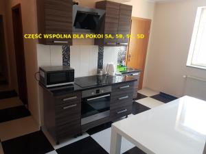 uma pequena cozinha com um micro-ondas e um fogão em Centrum Noclegowe II em Bydgoszcz