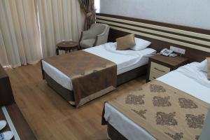 a hotel room with two beds and a chair at Olbia Hotel in Antalya +30 photos