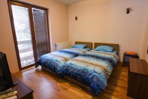 a bedroom with a bed with blue pillows on it at Villa 'Iva' in Mavrovo