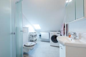 ein weißes Badezimmer mit einer Waschmaschine und einem Waschbecken in der Unterkunft Captain's Place in Dubrovnik
