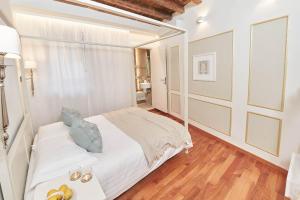 a white bedroom with a bed and a wooden floor at AppartamentoPalladio140 in Vicenza