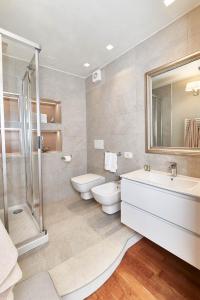 łazienka z 2 umywalkami, prysznicem i toaletą w obiekcie AppartamentoPalladio140 w mieście Vicenza