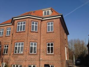 a large red brick building with white windows at Struckshus in Tønder