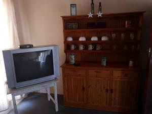 un televisor sentado en una mesa junto a un centro de entretenimiento de madera en Kalamata, en Beaufort West