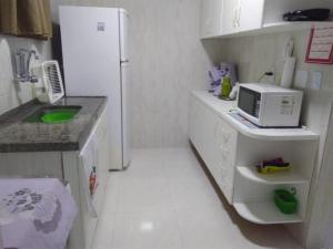 cocina con nevera blanca y microondas en Ótimo apto Praia Bessa en João Pessoa