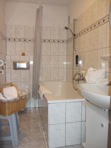 un bagno bianco con vasca e lavandino di Ferienhotel Schwarzwälder Hof a Feldberg