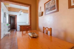 comedor con mesa de madera y escritorio en Vive la campiña Sevillana - Terraza y 3 Hab, en El Viso del Alcor