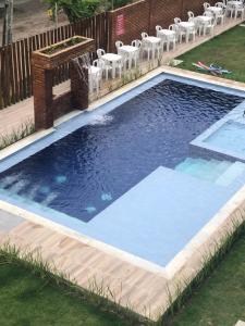 a swimming pool with a fountain in a yard at Apartamento alto padrao in Tamandaré