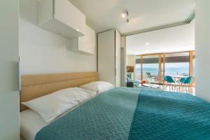 a bedroom with a bed and a view of the ocean at Old Village Brela in Brela