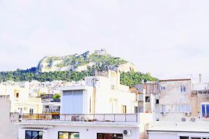 a group of buildings with a mountain in the background at Luxury 3BDroom View Apartment City Center in Athens