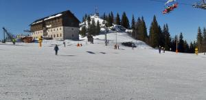 a group of people skiing on a snow covered slope at Apartmani Etno in Jahorina