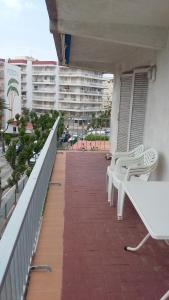 einen Balkon mit weißen Bänken und ein Gebäude in der Unterkunft La Pineda III in La Pineda