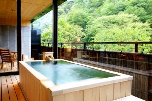 bañera de hidromasaje en el balcón con vistas a las montañas en Kaichoro, en Shibukawa