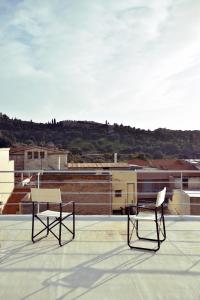 two chairs sitting on top of a roof at Apartment with Rooftop Terrace & Acropolis View in Athens