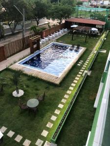 an overhead view of a swimming pool with chairs and a table at Apartamento alto padrao in Tamandaré