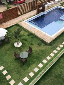 an overhead view of a pool with chairs and a table at Apartamento alto padrao in Tamandaré