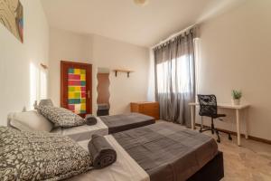 a bedroom with two beds and a desk and a chair at Bologna Fiera Fani Apartment in Bologna