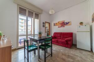 a living room with a table and a red couch at Bologna Fiera Fani Apartment in Bologna