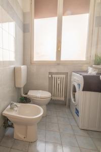 a bathroom with a toilet sink and a washing machine at Bologna Fiera Fani Apartment in Bologna