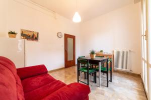een woonkamer met een rode bank en een tafel bij Bologna Fiera Fani Apartment in Bologna