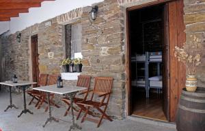 a group of tables and chairs next to a stone wall at Albergue San Lázaro in Sarria