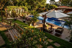 a backyard with a pool and a bench and an umbrella at Pousada Sítio Ipê in Viçosa do Ceará