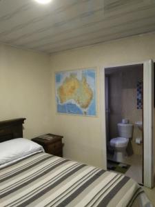 a bedroom with a bed and a map on the wall at Hostal Fisterra in Moniquirá