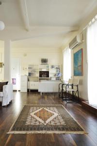 een woonkamer met een tapijt op een houten vloer bij Apartment with Rooftop Terrace & Acropolis View in Athene