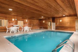 a swimming pool in a building with a wooden ceiling at Country Inn & Suites by Radisson, Dakota Dunes, SD in Dakota Dunes