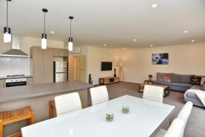 a kitchen and living room with a white table and chairs at Weston Villa - Christchurch Holiday Homes in Christchurch