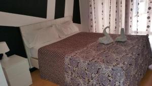 Un dormitorio con una cama con dos cisnes. en Hostal Lima en Valladolid
