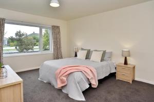 a bedroom with a large bed and a window at Weston Villa - Christchurch Holiday Homes in Christchurch