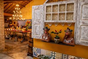 two statues of women on a shelf in a restaurant at Pousada Sítio Ipê in Viçosa do Ceará