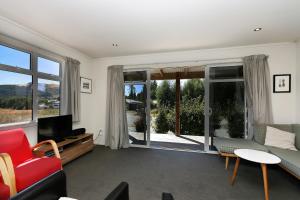 un salon avec un canapé et une télévision dans l'établissement Matagouri Cottage - Lake Tekapo, à Lac Tekapo