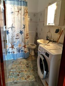 a bathroom with a toilet and a washing machine at Myrto's Apartment No15 in Loutra Oraias Elenis