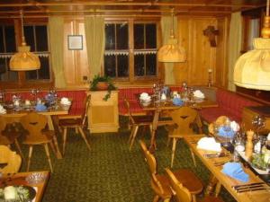 une salle à manger avec des tables et un canapé rouge dans l'établissement Land- & Panoramagasthof Schöne Aussicht, à Viktorsberg