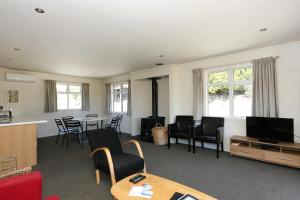 a living room with a tv and a table and chairs at Totara Cottage in Lake Tekapo
