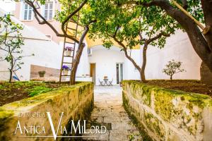 a walkway in front of a house with trees at Dimora Antica Via MiLord in Monopoli